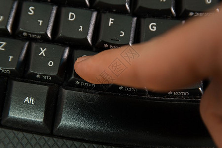 男人在无线键盘上打字用希伯来语和英字母打按复制钮顶级视图图片