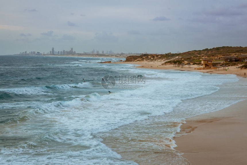 日落时在以色列帕尔马希姆海滩的波浪上冲图片