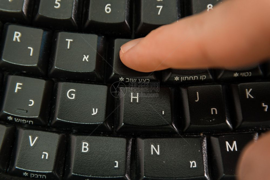 男人在无线键盘上打字用希伯来语和英字母打按Redo钮顶级视图图片