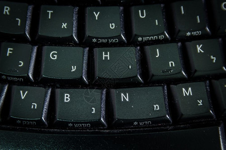 带有希伯来语和英字母的键盘无线键盘顶端视图关闭黑暗气氛图片