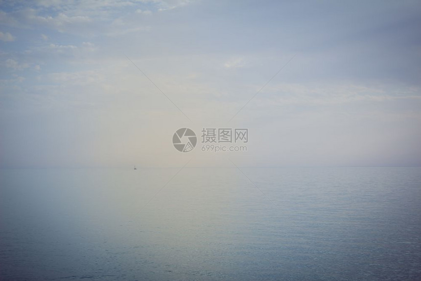 帆船在公海上航行船离地平线很远日落的颜色图片