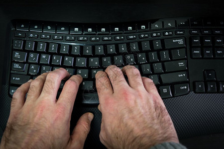 以希伯来语和英字母在键盘上打的人无线键盘顶端视图黑暗气氛图片