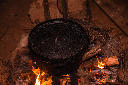 火锅炉晚上在烧营火时用锅炉煮饭背景