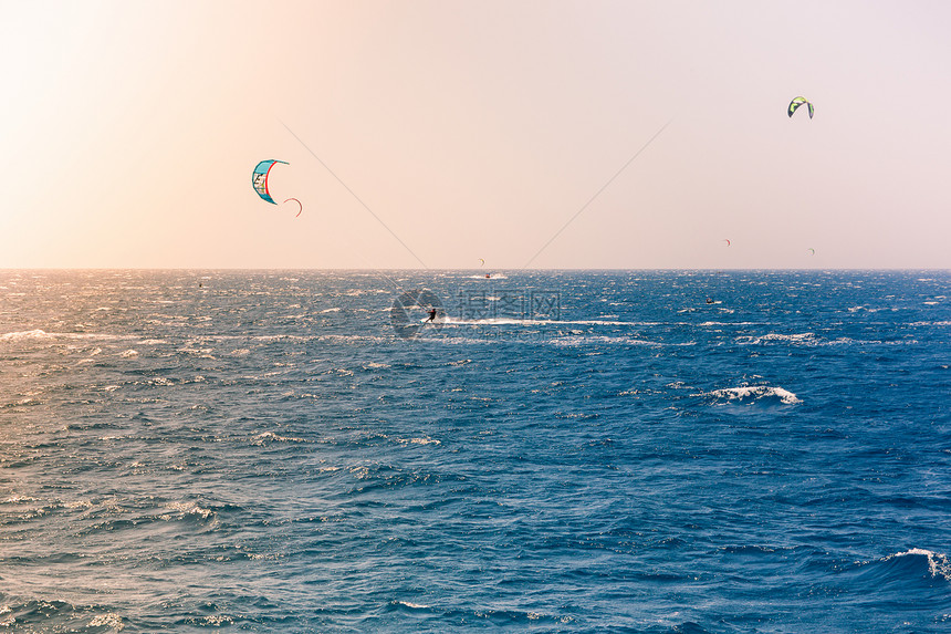风帆在红海航行以色列伊拉特海滩附近亮橙色光从左边的太阳中射出图片