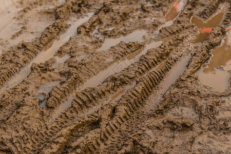 水泥土潮湿的棕色泥土和自行车轮胎轨迹的纹理背景
