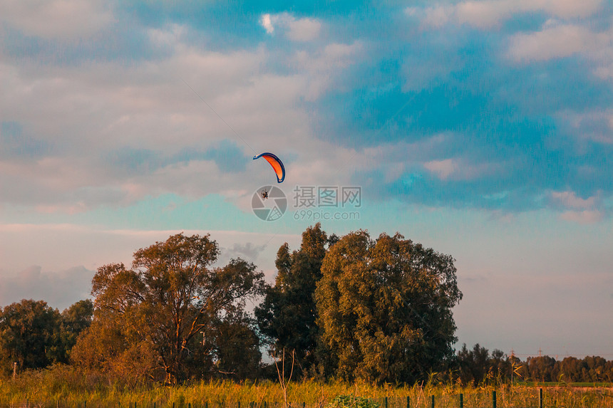 日落时在农村地区飞行的机动滑翔图片
