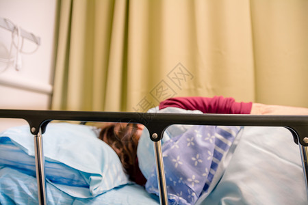 女病人躺在医院房间的床上图片