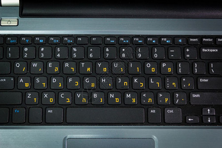 带有希伯来语和英字母的键盘笔记本键盘顶端视图黑暗气氛图片