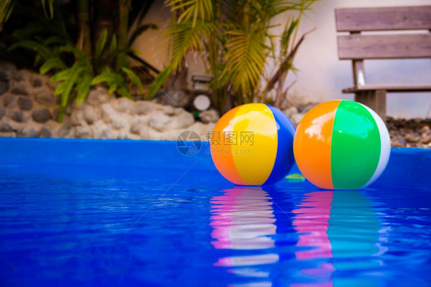 游泳池里漂浮着多彩的海滩球图片