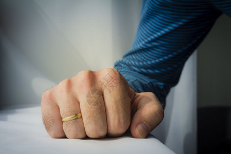 戴婚戒的男人用白布把手捏在背景上图片