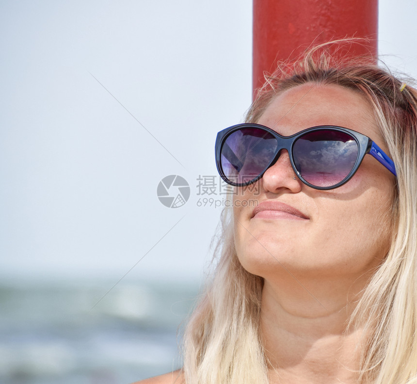 沙滩上戴着太阳眼镜的金发女孩沙滩上躺着的女孩图片