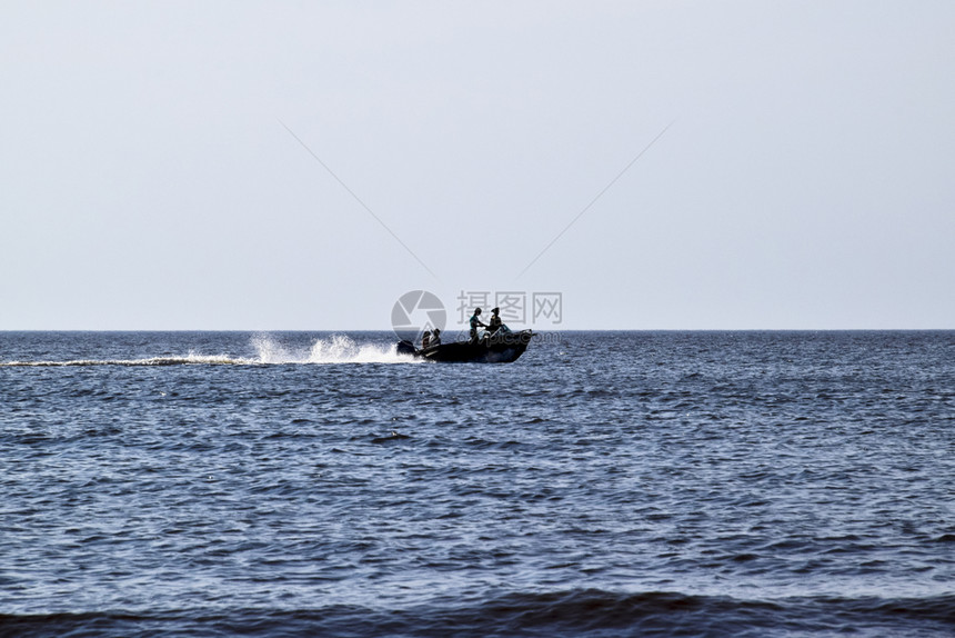 船在海上冲浪船的人晚海景远背下停靠在船上的机动只和在上的人海晚的景在背下停靠在船上的人停靠在船上的人图片