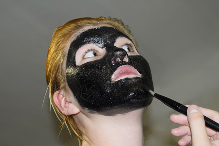 化妆面罩的女孩清洗阿司匹林和活碳的面具黑色化妆罩图片