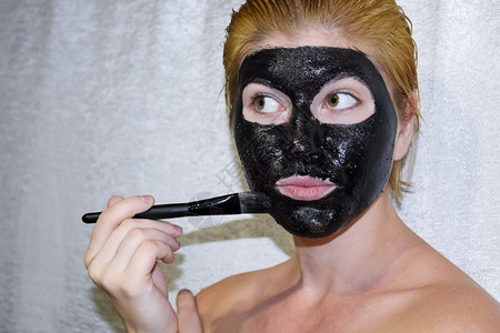 化妆面罩的女孩清洗阿司匹林和活碳的面具黑色化妆罩图片