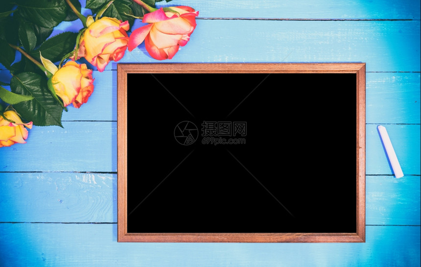 清空黑色板和黄玫瑰花束蓝木背景旧年图片