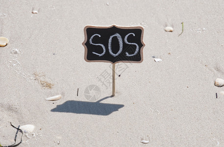 黑色木板上面刻着SOS在沙上黑色木板上面刻着SOS图片