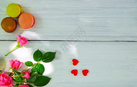 白色木背景和一束粉红玫瑰花上面有三个多色的红木右边空图片