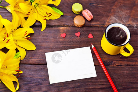 空的卡片和一杯咖啡在个黄色的杯子在旁边一束黄色的百合花图片