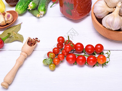 红樱桃番茄和汤匙白底的香料图片