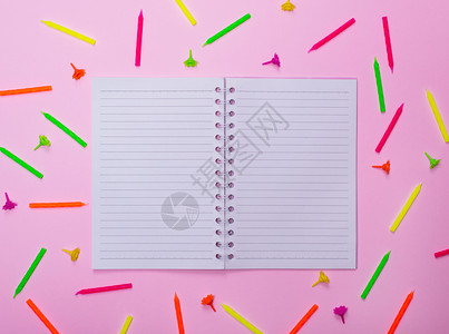 在一根蜡烛中间的排线上打开空白笔记本用于粉红背景的节日蛋糕图片