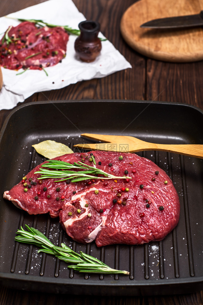 黑煎锅上的牛肉排配有香料和迷迭顶层风景图片