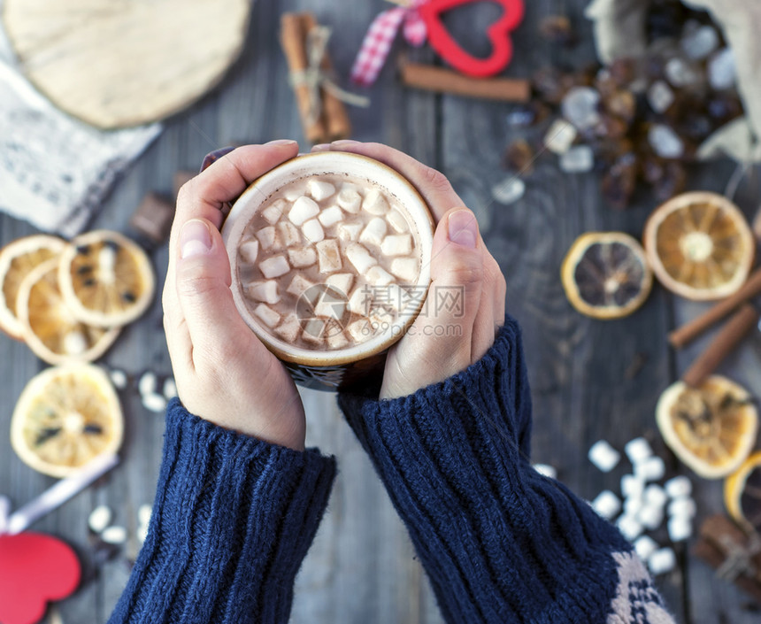 热巧克力杯加棉花糖在女手中顶部风景图片
