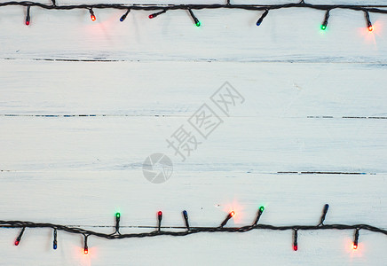 圣诞园地白木表面有彩色小灯泡背景图片