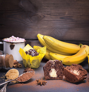 香蕉松饼半个黑背景的填料切成半块后面的热巧克力加棉花糖和新鲜香蕉图片