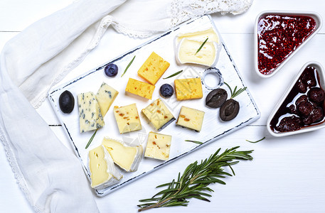 白木板上色质顶端的白奶酪罗克福特红伯切达和配有胡桃的奶酪图片