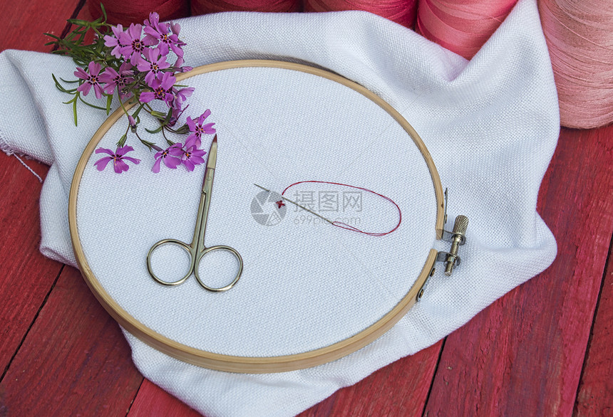 缝纫和刺绣工作场所针织的木刺绣框架红线和粉白织物图片