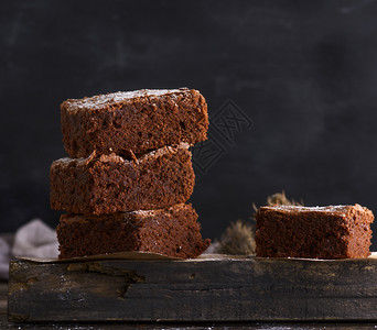木板上的巧克力烤面包饼关闭巧克力面包蛋糕馅饼的正方块背景图片