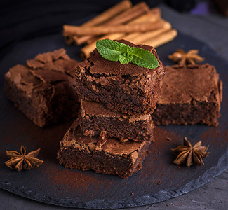 黑色石墨板上的烤巧克力蛋糕正方形片上面的巧克力蛋糕烤巧克力蛋糕正方形片背景图片