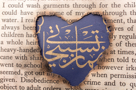 阿拉伯文字的心形洞烧焦纸背景图片