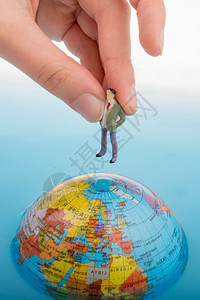 手握着一个小雕像在水中全球顶端背景图片
