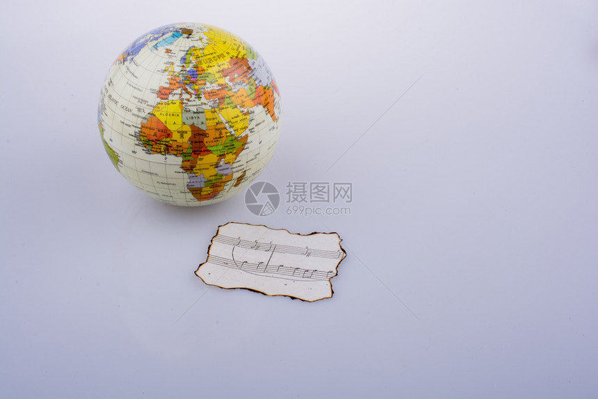 烧焦纸上的音乐笔记和一个小模样的地球图片