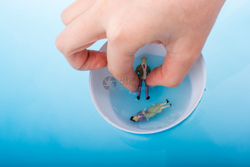 蓝色水中漂浮着雕像的小模型地球图片