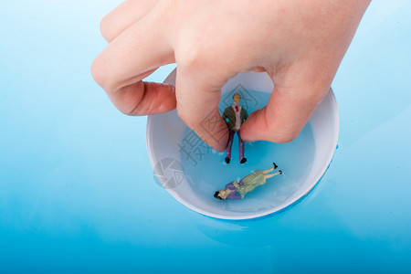 蓝色水中漂浮着雕像的小模型地球背景图片