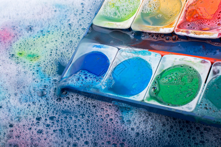 在泡沫覆盖的水中溶解彩漆图片