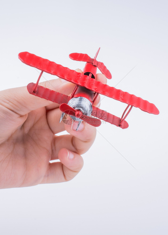 手中拿着一架红色玩具飞机图片