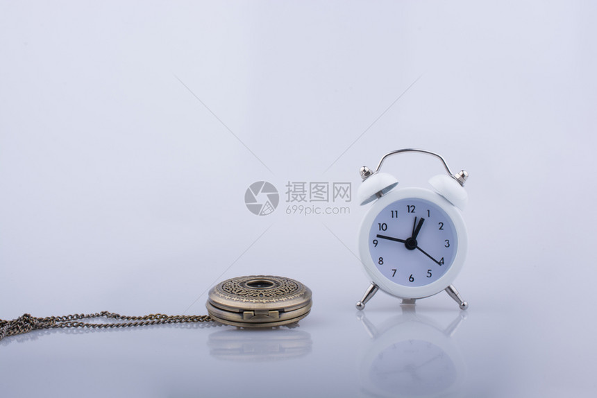 白色背景上的闹钟和袖口手表图片