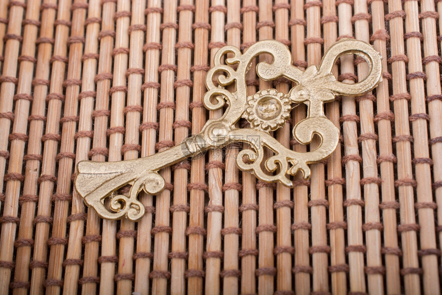重新样式化的金色密钥放在稻草背景上的金色密钥图片