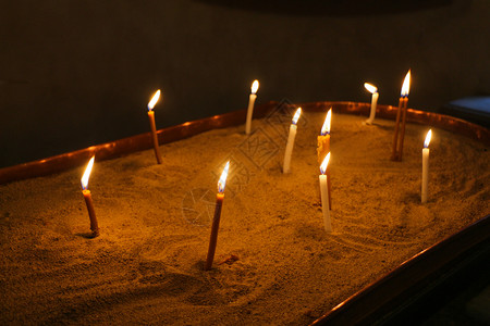 在教堂黑暗背景下燃烧的蜡烛背景图片