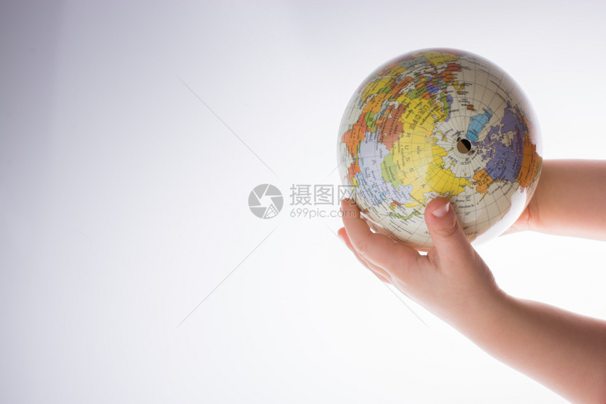 儿童在白色背景下持有一个地球图片