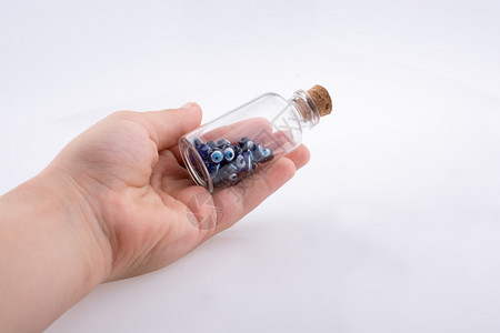 小玻璃瓶手拿着蓝色邪恶眼珠图片