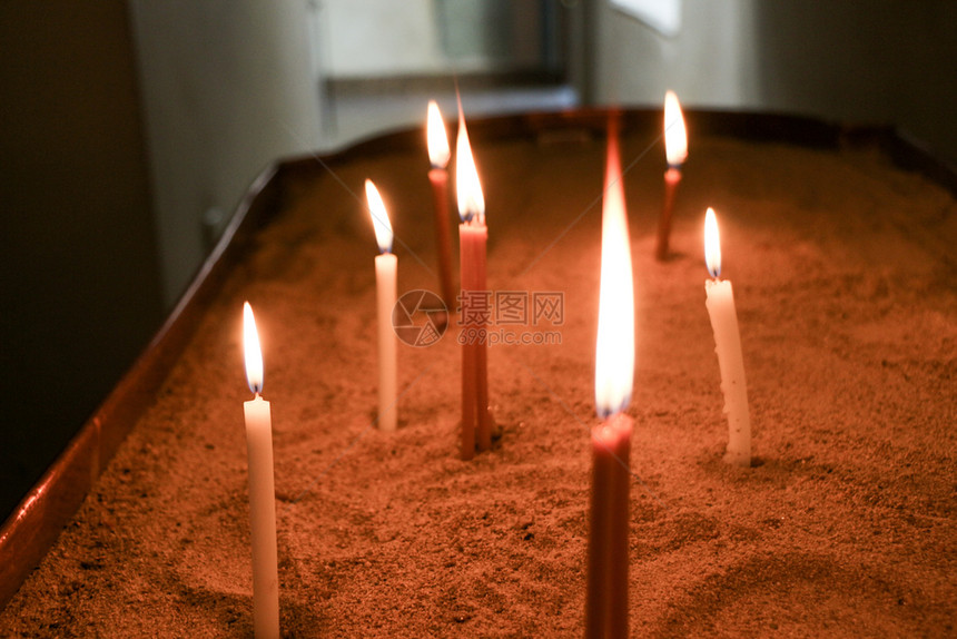 在教堂黑暗背景下燃烧的蜡烛图片