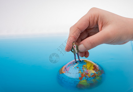手握着一个小雕像在水中全球顶端背景图片