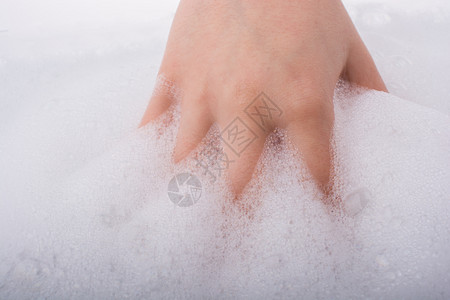 泡沫背景下的洗手和肥皂泡沫图片