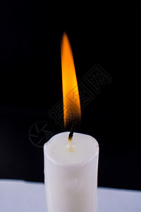燃烧蜡烛在黑色背景上燃烧白蜡烛图片