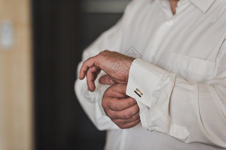商人穿好会议服商人用紧身扣子把袖在一件白色49衬衫的袖子上图片