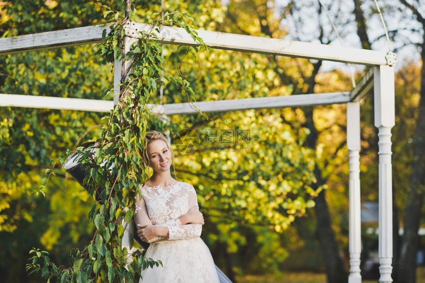 新娘站在露台杂草丛生的植物旁的画像花园露台背景上穿着白色礼服的新娘画像图片